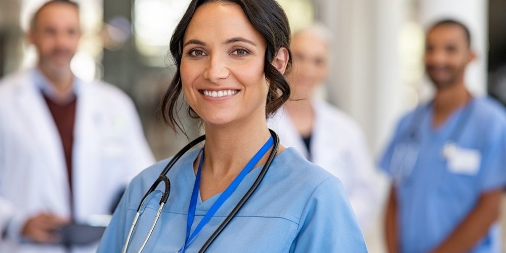 Portrait,Of,Happy,Young,Nurse,In,Uniform,With,Healthcare,Team
